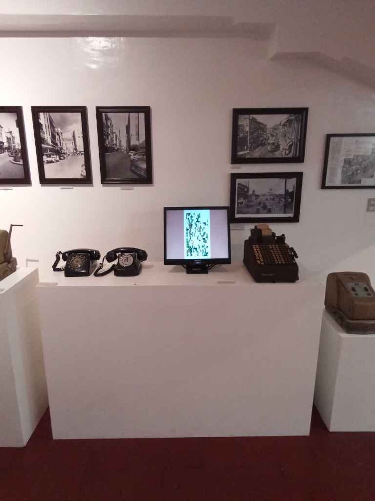 Insulae Incognita installed on a small monitor among telephones and other artifacts in the First United Building Museum.